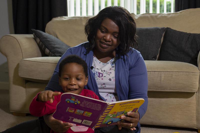A woman and toddler reading a picture book together