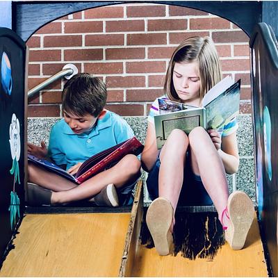 two children reading books 