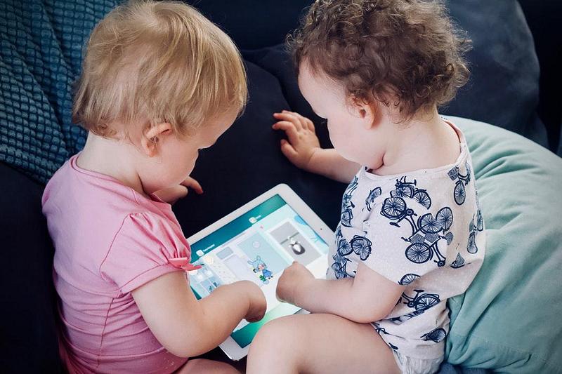 Two young children playing on a tablet