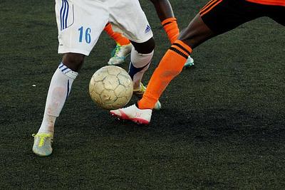 Close up feet and ball in football tackle