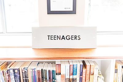 'Teenagers' sign above bookshelf in library 