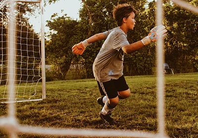 Young boy diving in football goals