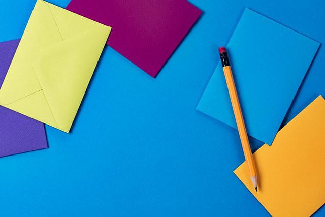 Blue desk with colourful notepaper and a pencil