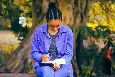 Teenager reading book outside