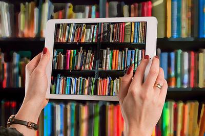 Tablet being used to take a photograph of bookshelves