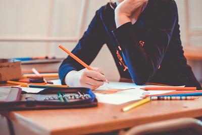 Person sitting with pens and paper