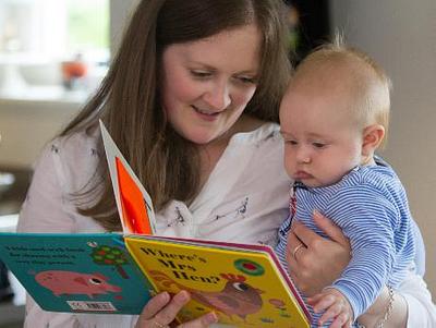 Woman reading 'Where's Mrs Hen' to her baby