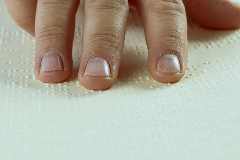 A hand feeling braille