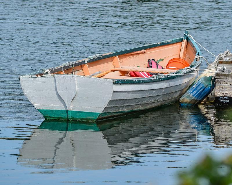 A rowboat tied to a pier on a lake