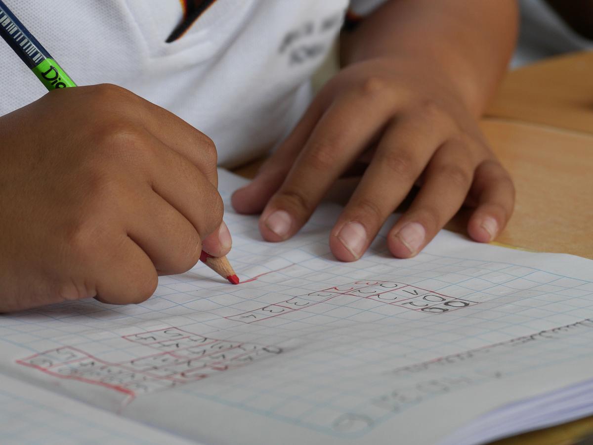 Close up of child's hands doing numeracy exercise