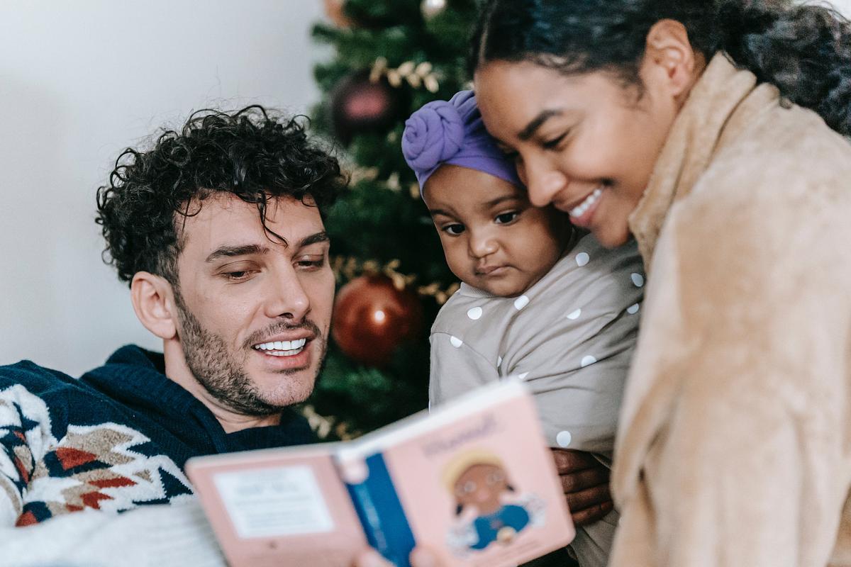 Parents reading a picture book to a baby