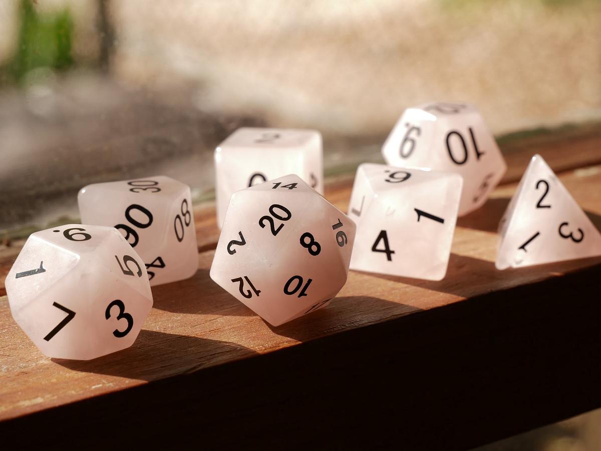 Various shapes of dice sitting on a wooden table