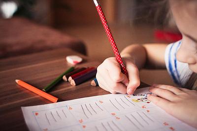 A child writing and drawing in a notebook